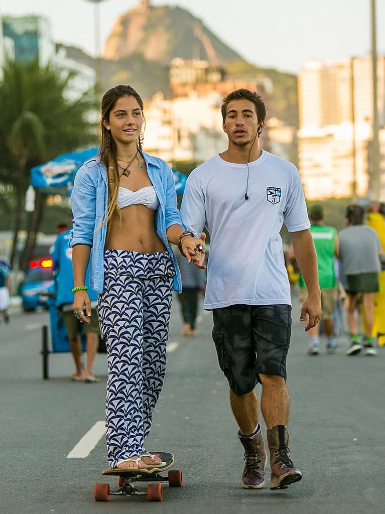 Jóvenes disfrutando de un paseo en una calle urbana con monumentos y naturaleza de fondo, promoviendo innovación en soluciones tecnológicas y servicios para la movilidad en Soluciones AIT.