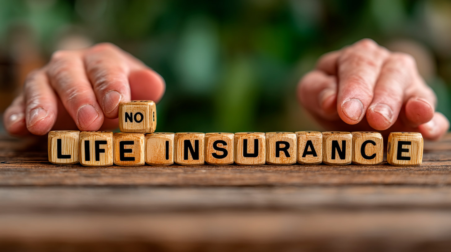 Manos colocando bloques de madera que forman la frase "NO LIFE INSURANCE" en un fondo natural, destacando soluciones innovadoras en seguros de vida y salud.